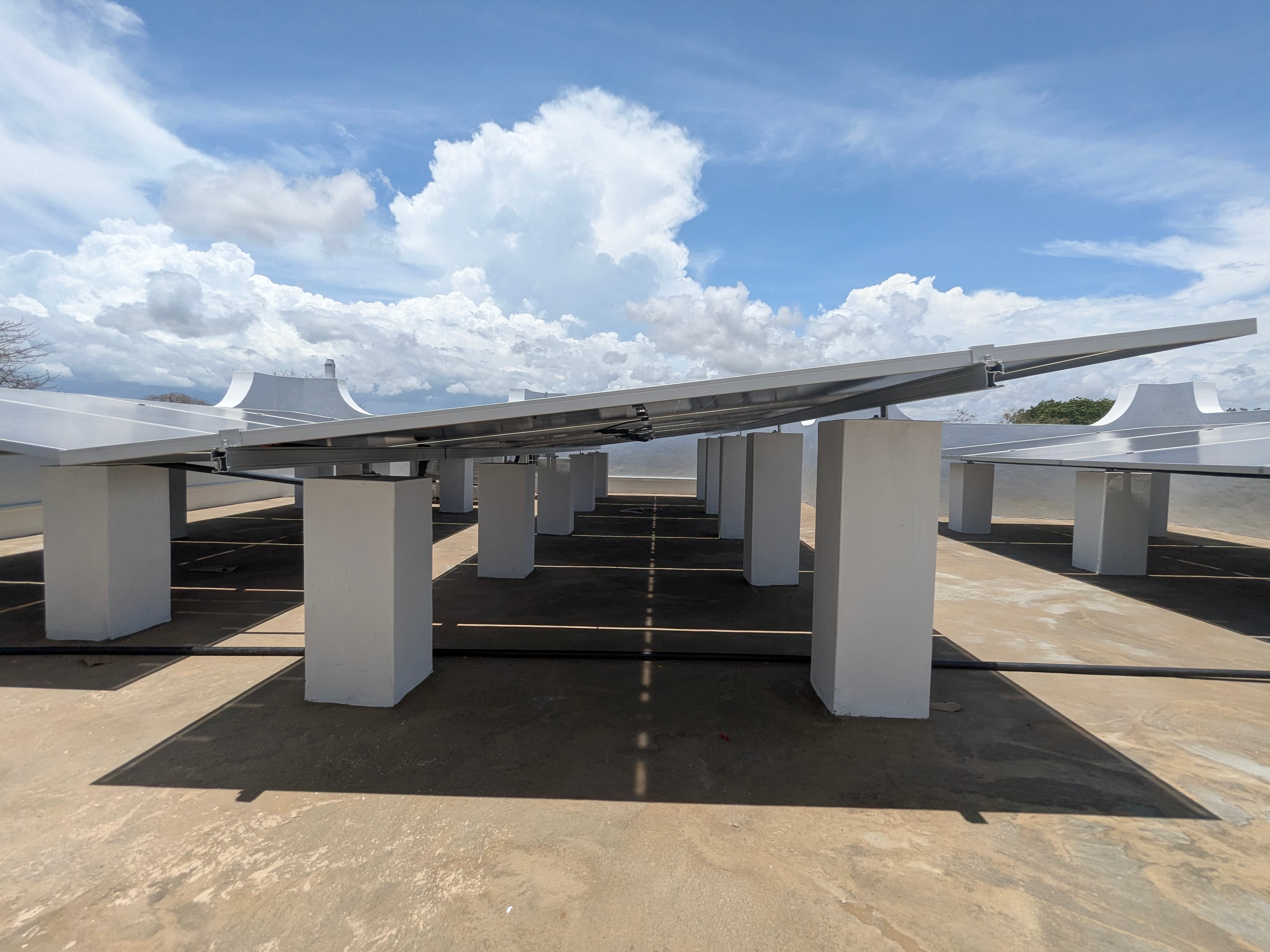 Elevated solar canopy array on raised mounts at a commercial property
